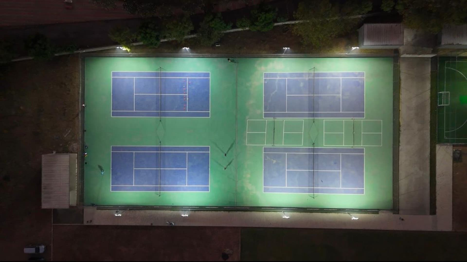 Aerial view of the floodlit courts at Drona Sports Academy